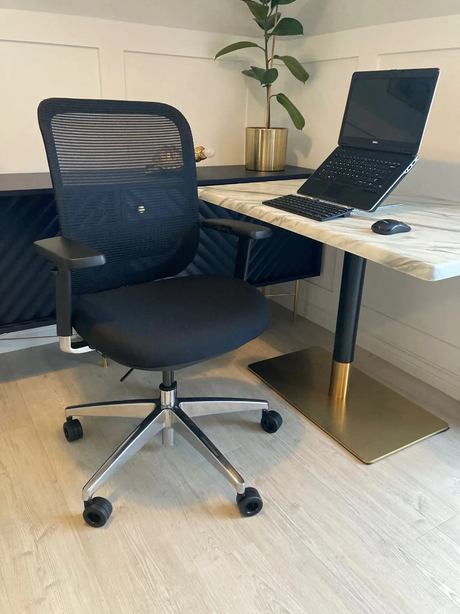 Ergonomic office chair at a wooden desk with laptop